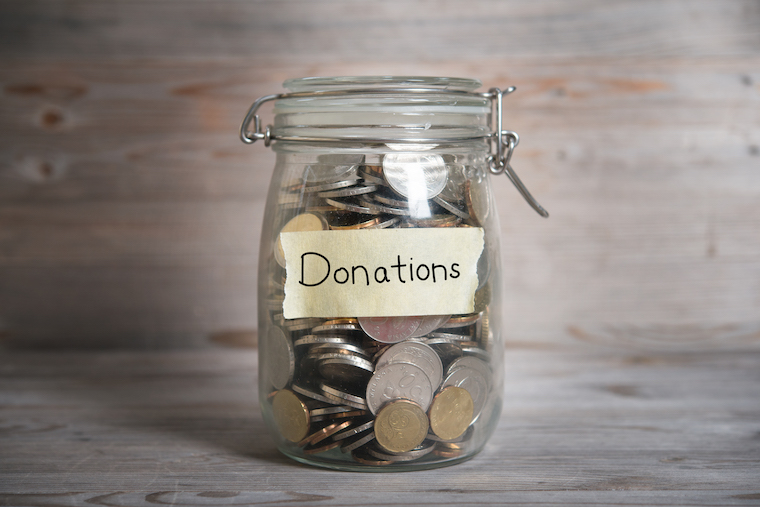 Coins in glass money jar with donations label