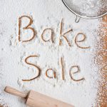 "bake sale" written in flour on a kitchen table